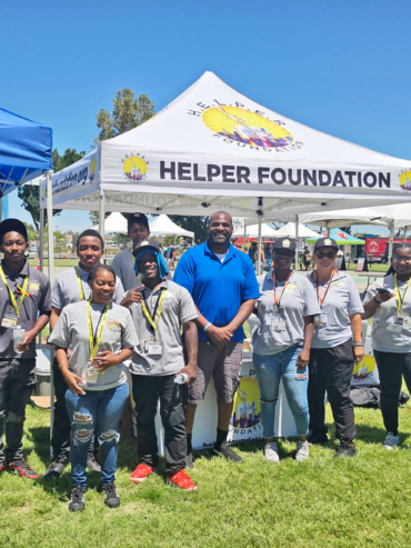 Getro Elize posing with staff in front of helper foundation canopy