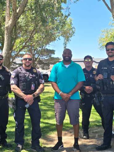 Getro Elize posing together with multiple local police officers