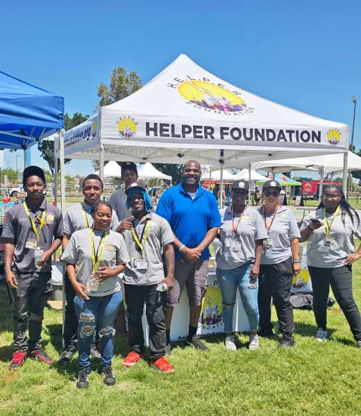 Getro Elize posing with staff in front of helper foundation canopy