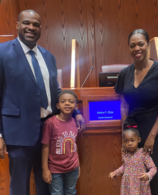 Getro Elize posing with wife, son and daughter in conference room